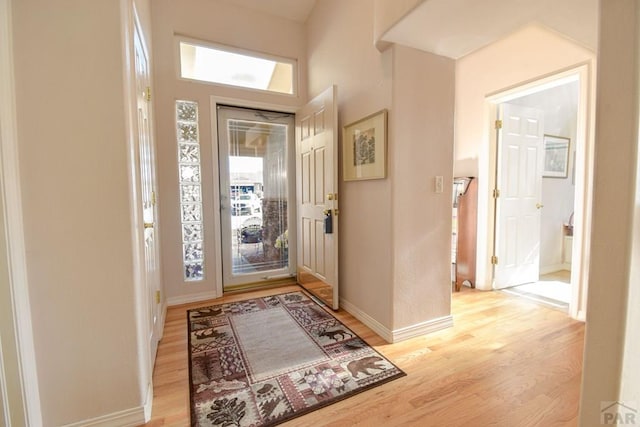 entryway featuring light wood-style flooring, plenty of natural light, and baseboards