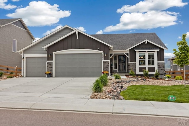 16840 New Autum Dr, Monument, CO 80132 - craftsman house featuring an attached garage, driveway, stone siding, and board and batten siding
