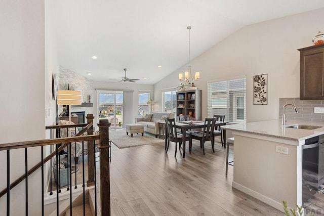 16840 New Autum Dr, Monument, CO 80132 - kitchen featuring a sink, vaulted ceiling, backsplash, light wood-style floors, and dishwashing machine