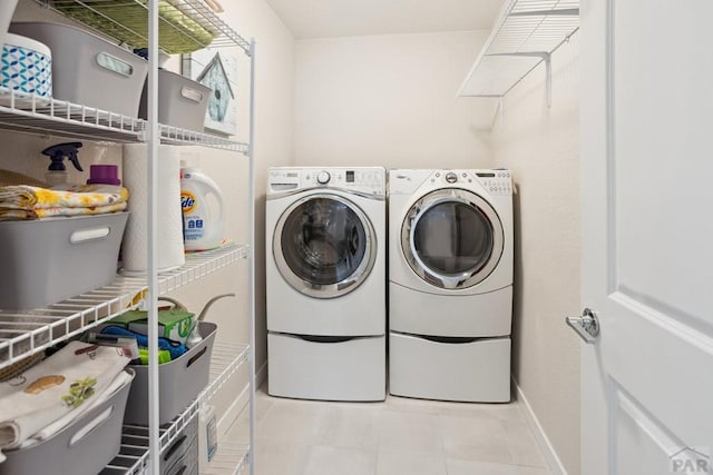 16840 New Autum Dr, Monument, CO 80132 - laundry room with washing machine and dryer, baseboards, and light tile patterned flooring