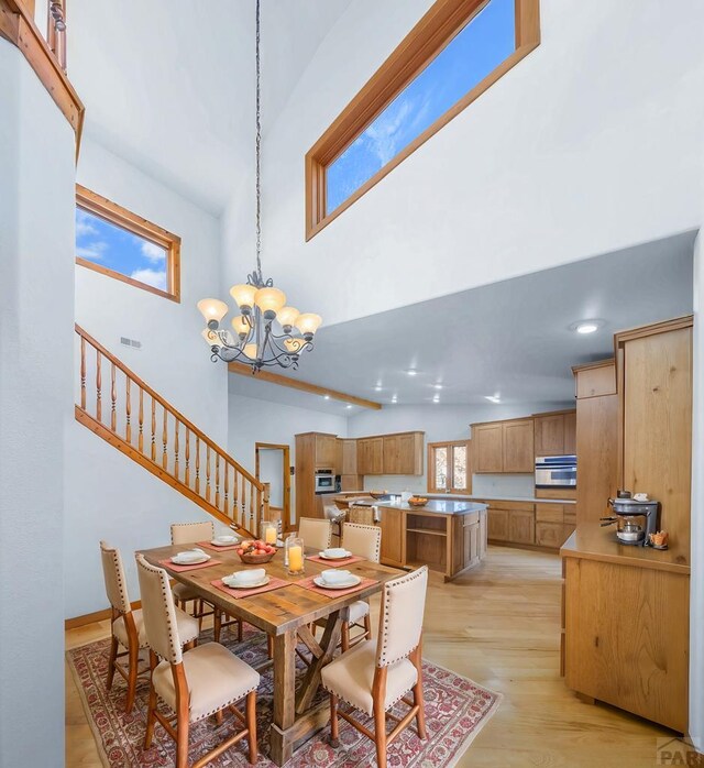 unfurnished room featuring light wood-type flooring, visible vents, and vaulted ceiling