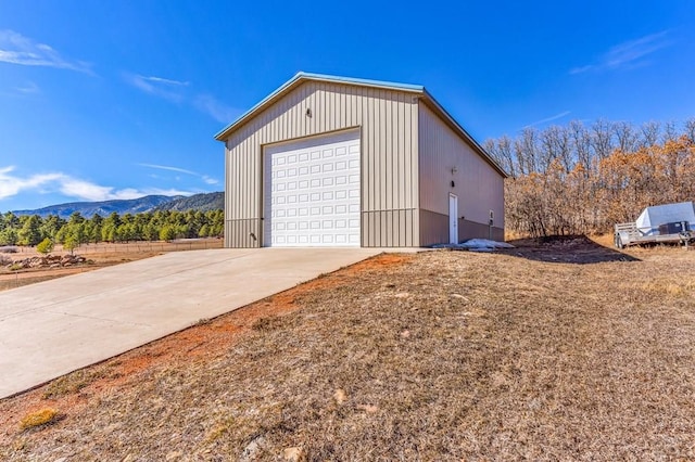 detached garage with driveway and a mountain view