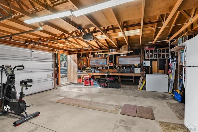 garage with refrigerator, a workshop area, and a garage door opener