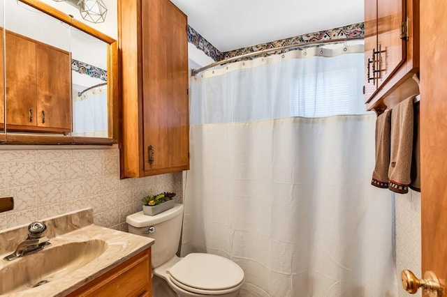 full bathroom featuring decorative backsplash, tile walls, vanity, and toilet