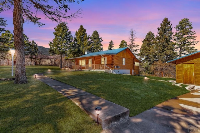 exterior space with a front yard, a chimney, and log siding