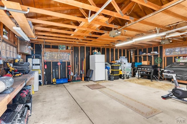 garage with a garage door opener and freestanding refrigerator