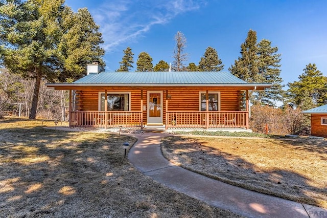 log cabin featuring covered porch, metal roof, a chimney, and log siding