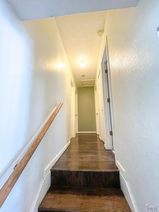 1320 Bradish Ave, La Junta, CO 81050 - stairway with wood finished floors, baseboards, and a textured ceiling