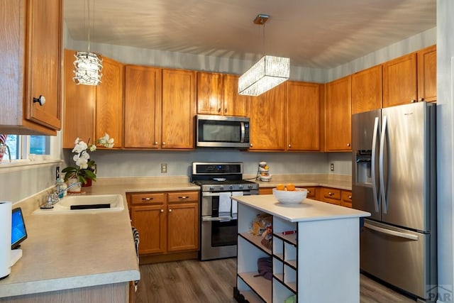 kitchen with stainless steel appliances, light countertops, dark wood-type flooring, and a sink