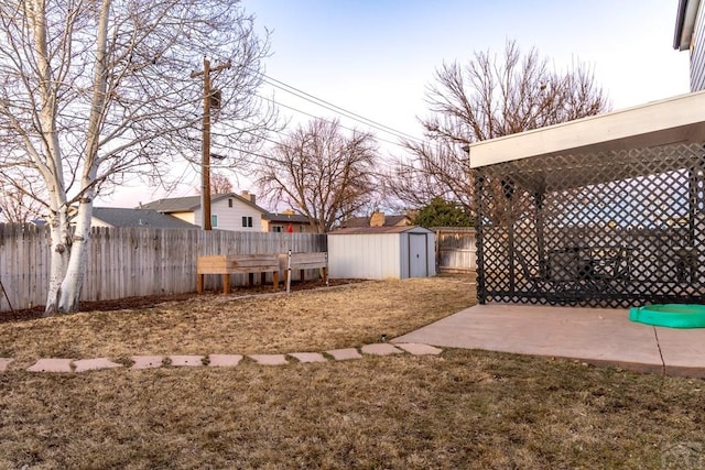 view of yard featuring a fenced backyard, a patio, a storage shed, and an outdoor structure