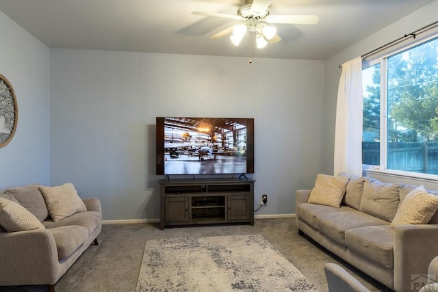 living area with a ceiling fan, baseboards, and light carpet