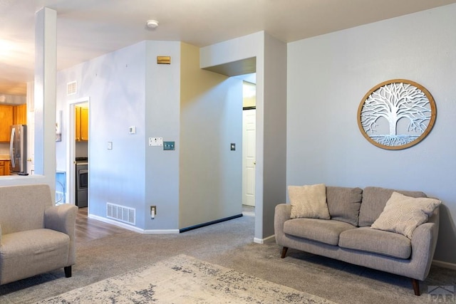 sitting room with visible vents, baseboards, and carpet flooring