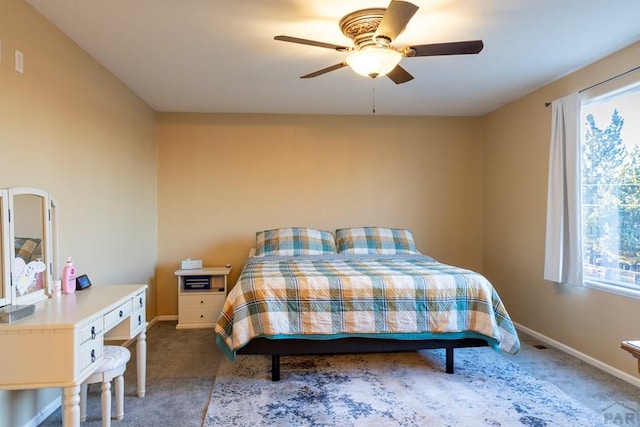 carpeted bedroom with a ceiling fan and baseboards