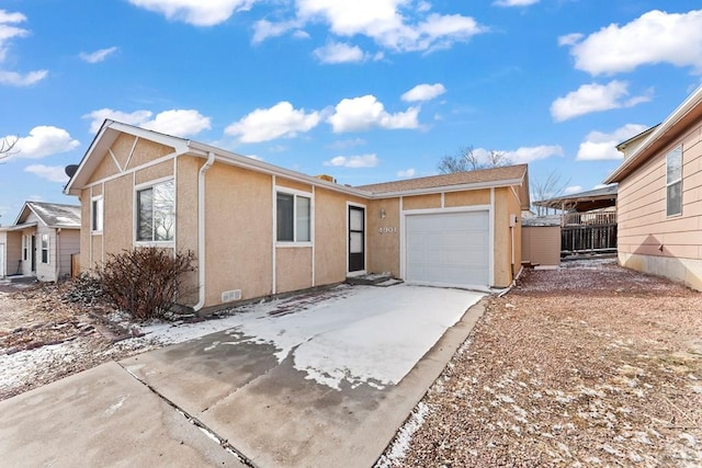 view of front of home with a garage, concrete driveway, fence, and stucco siding