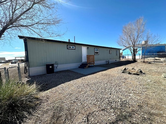 rear view of property with entry steps and fence