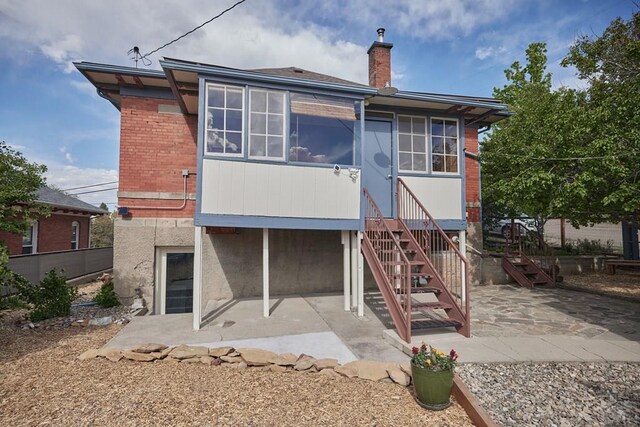 315 S Oak St, Trinidad, CO 81082 - rear view of property featuring a patio, brick siding, and a chimney