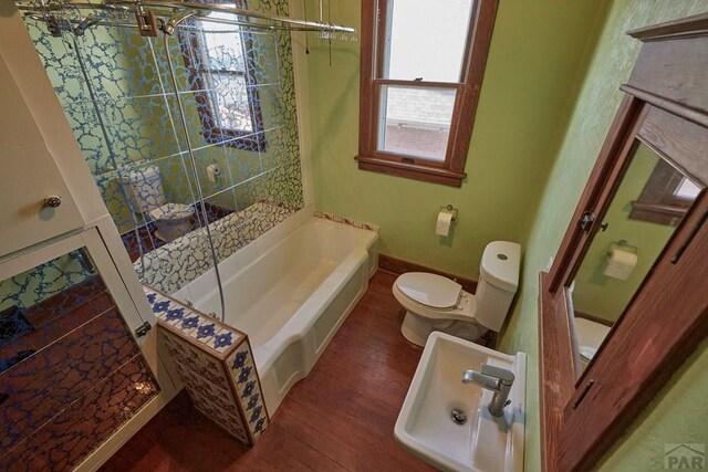 315 S Oak St, Trinidad, CO 81082 - bathroom featuring toilet, hardwood / wood-style flooring, a bath, a shower with door, and baseboards