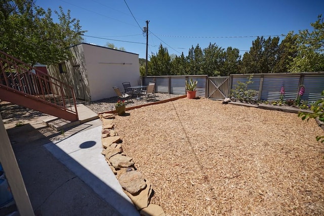 315 S Oak St, Trinidad, CO 81082 - fenced backyard featuring a gate, a patio area, and an outbuilding