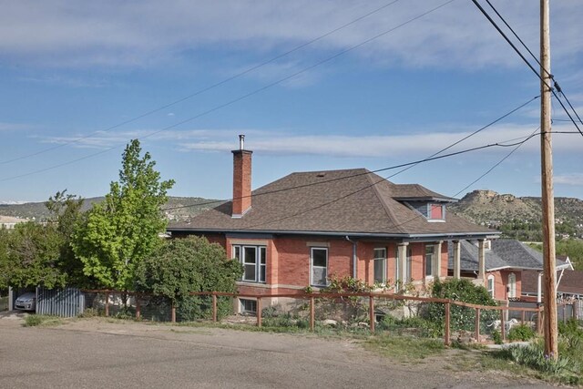 315 S Oak St, Trinidad, CO 81082 - view of front of property with a chimney, brick siding, and roof with shingles