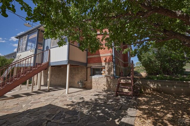 315 S Oak St, Trinidad, CO 81082 - rear view of house featuring a patio, stairway, and brick siding