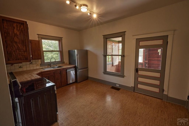 315 S Oak St, Trinidad, CO 81082 - kitchen featuring stainless steel appliances, a sink, baseboards, light countertops, and decorative backsplash