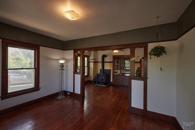 315 S Oak St, Trinidad, CO 81082 - unfurnished living room featuring dark wood finished floors, baseboards, and a wood stove