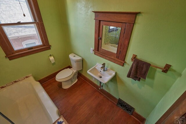 315 S Oak St, Trinidad, CO 81082 - bathroom featuring a sink, toilet, wood finished floors, baseboards, and a bathtub