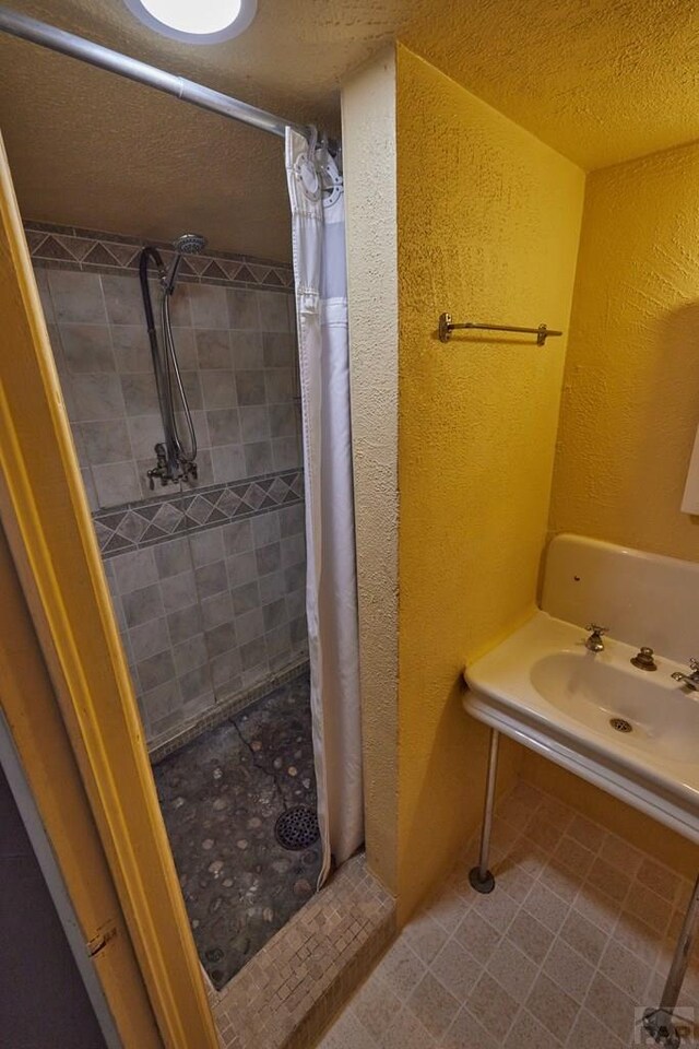 315 S Oak St, Trinidad, CO 81082 - full bathroom with a tile shower, a textured wall, a textured ceiling, and a sink