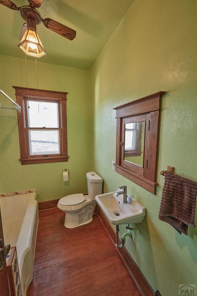 315 S Oak St, Trinidad, CO 81082 - full bathroom with wood-type flooring, a bath, toilet, a sink, and a ceiling fan