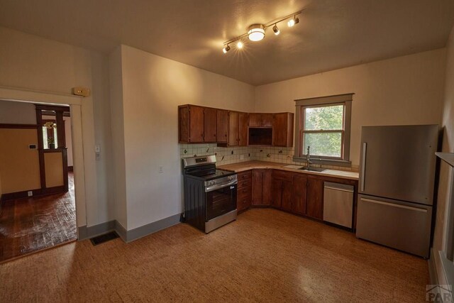 315 S Oak St, Trinidad, CO 81082 - kitchen featuring appliances with stainless steel finishes, a sink, light countertops, and brown cabinetry
