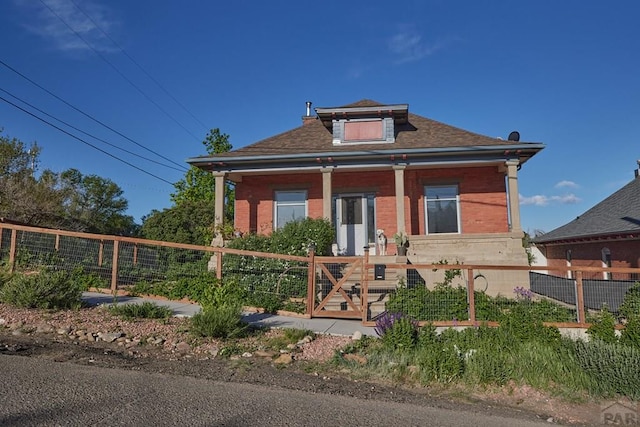 315 S Oak St, Trinidad, CO 81082 - bungalow with a fenced front yard, covered porch, brick siding, and a gate