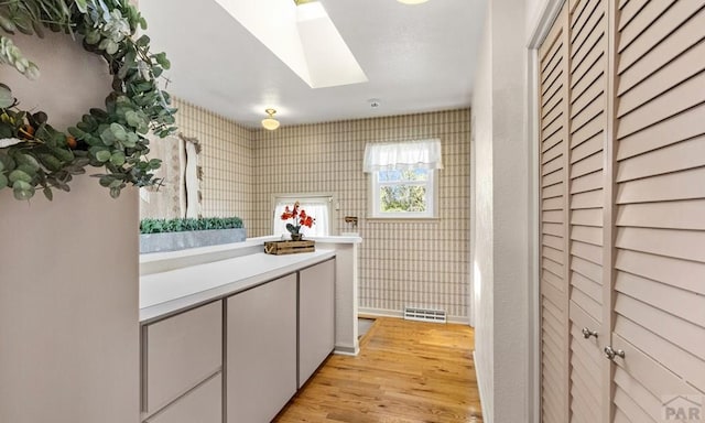 4321 Goodnight Ave, Pueblo, CO 81005 - laundry area featuring light wood-style flooring, visible vents, and a skylight