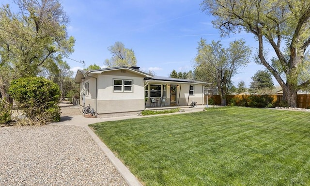 4321 Goodnight Ave, Pueblo, CO 81005 - view of front of property with roof mounted solar panels, fence, a porch, and a front lawn