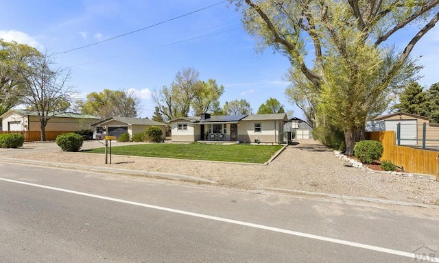 4321 Goodnight Ave, Pueblo, CO 81005 - ranch-style house featuring roof mounted solar panels, a front yard, and fence