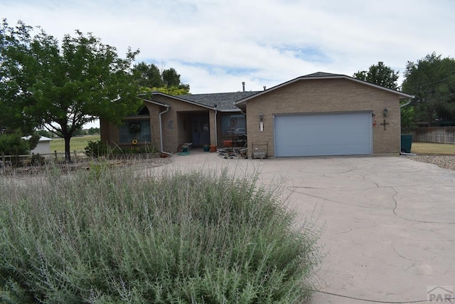 single story home with brick siding, driveway, and an attached garage