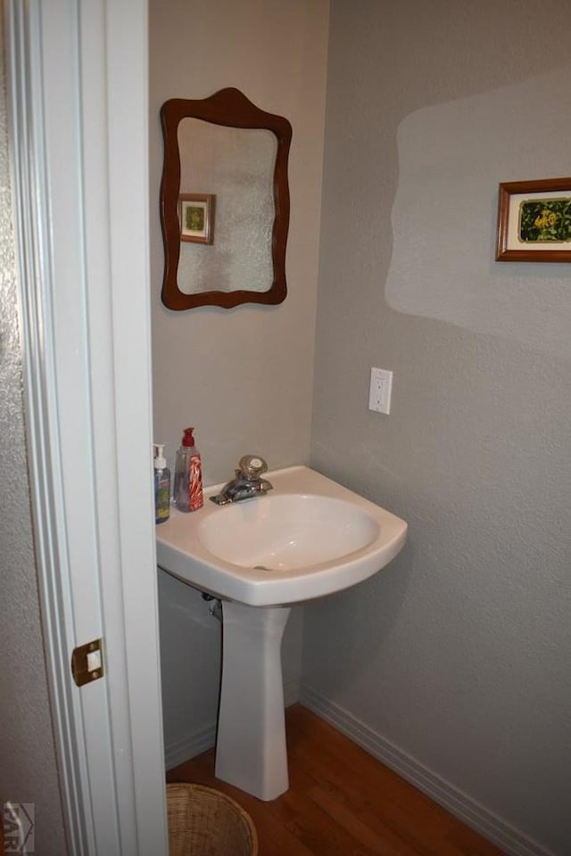 bathroom with baseboards and wood finished floors