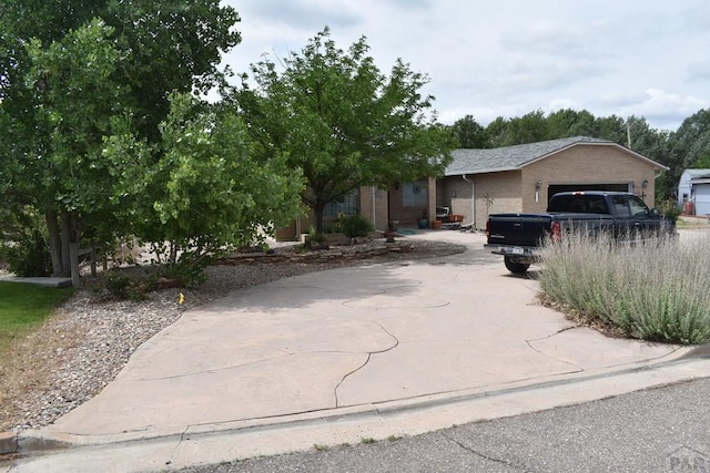 view of front of home featuring a garage, driveway, and brick siding