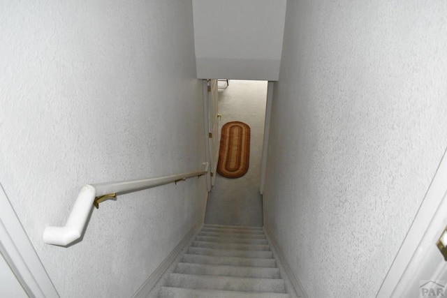 staircase featuring a textured wall