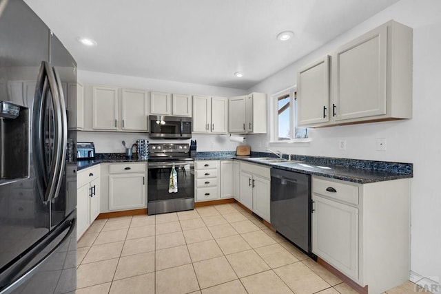 kitchen with appliances with stainless steel finishes, light tile patterned flooring, and white cabinets