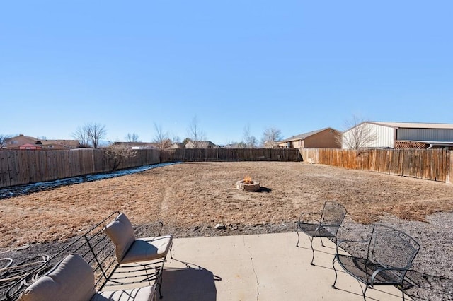 view of yard featuring a patio area, a fenced backyard, and a fire pit