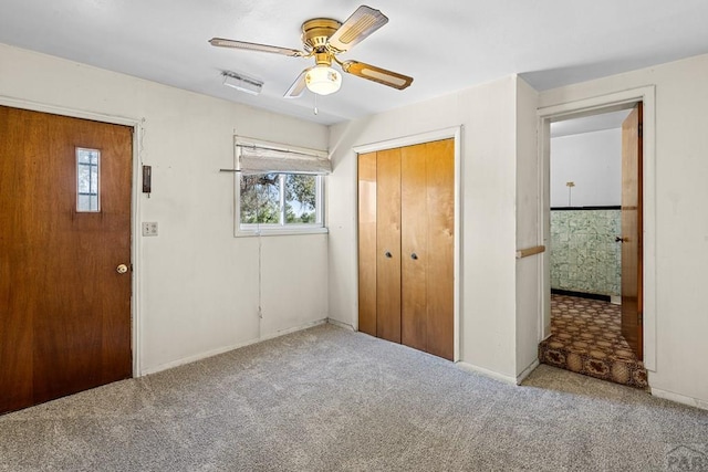 unfurnished bedroom with carpet, a closet, and ceiling fan