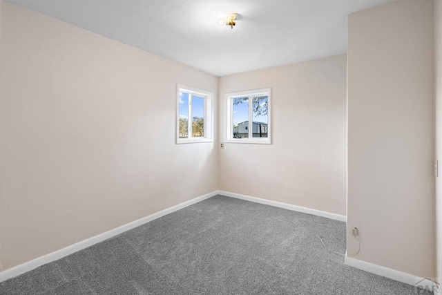 empty room featuring carpet floors and baseboards