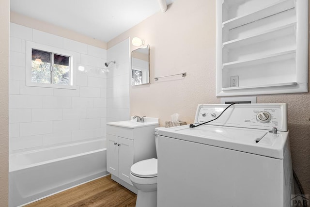 full bathroom featuring washer / clothes dryer, toilet, washtub / shower combination, vanity, and wood finished floors