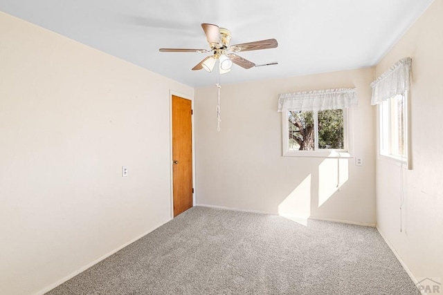 carpeted spare room featuring ceiling fan