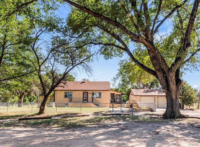 ranch-style house featuring a fenced front yard and stucco siding