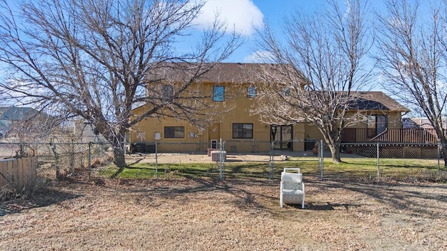 rear view of property featuring a fenced front yard and stucco siding