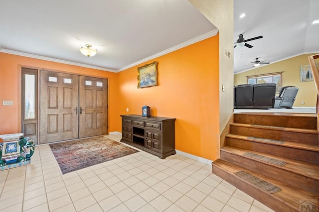 entrance foyer with light tile patterned floors, baseboards, vaulted ceiling, and crown molding