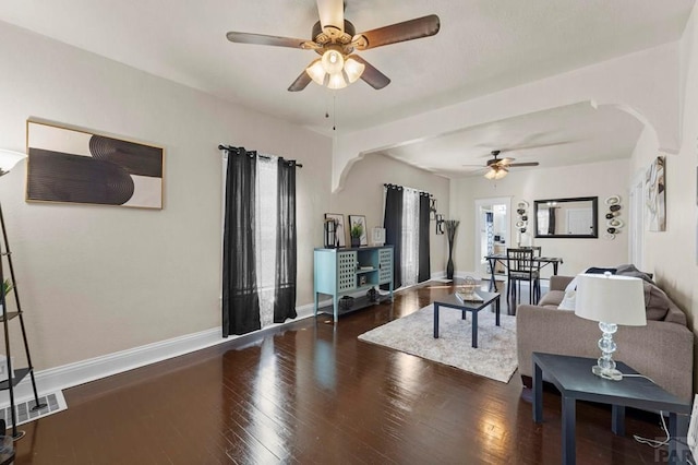 living area with dark wood-style floors, visible vents, and baseboards