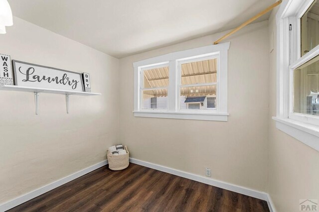 unfurnished room with baseboards and dark wood-style flooring