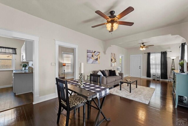 dining area featuring ceiling fan, dark wood finished floors, and baseboards